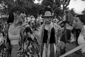 A joyful group interaction captured in black and white at an outdoor festival.