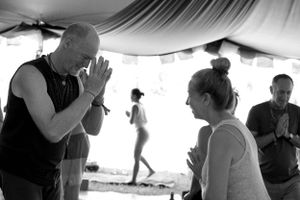 Black and white photo capturing a moment of meditation between participants under a tent.