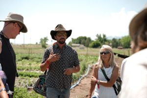 Group discussion taking place in a sunny agricultural field.