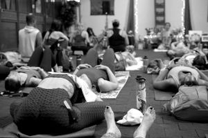 People relaxing on yoga mats during an indoor wellness session.
