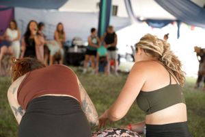 Participants attending a wellness session under a draped canopy tent.
