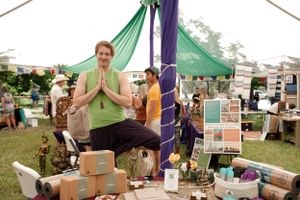 Vendor display at outdoor market with colorful fabric decorations and product displays.