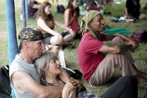 People relax on the grass during an outdoor gathering.