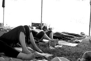 Black and white image of people relaxing on grass outdoors.