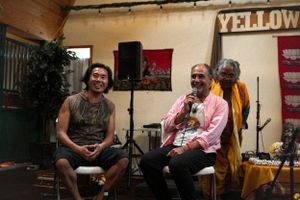 Two speakers engage in conversation during an outdoor event at Yellow Bar.