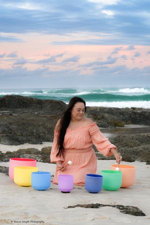 Portrait of a young lady on the beach with her sound bowls