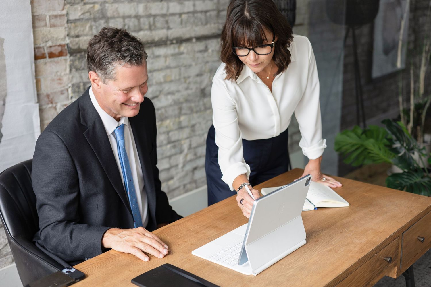 Personal branding photo of entrepreneur in downtown London Ontario coaching another entrepreneur on his laptop