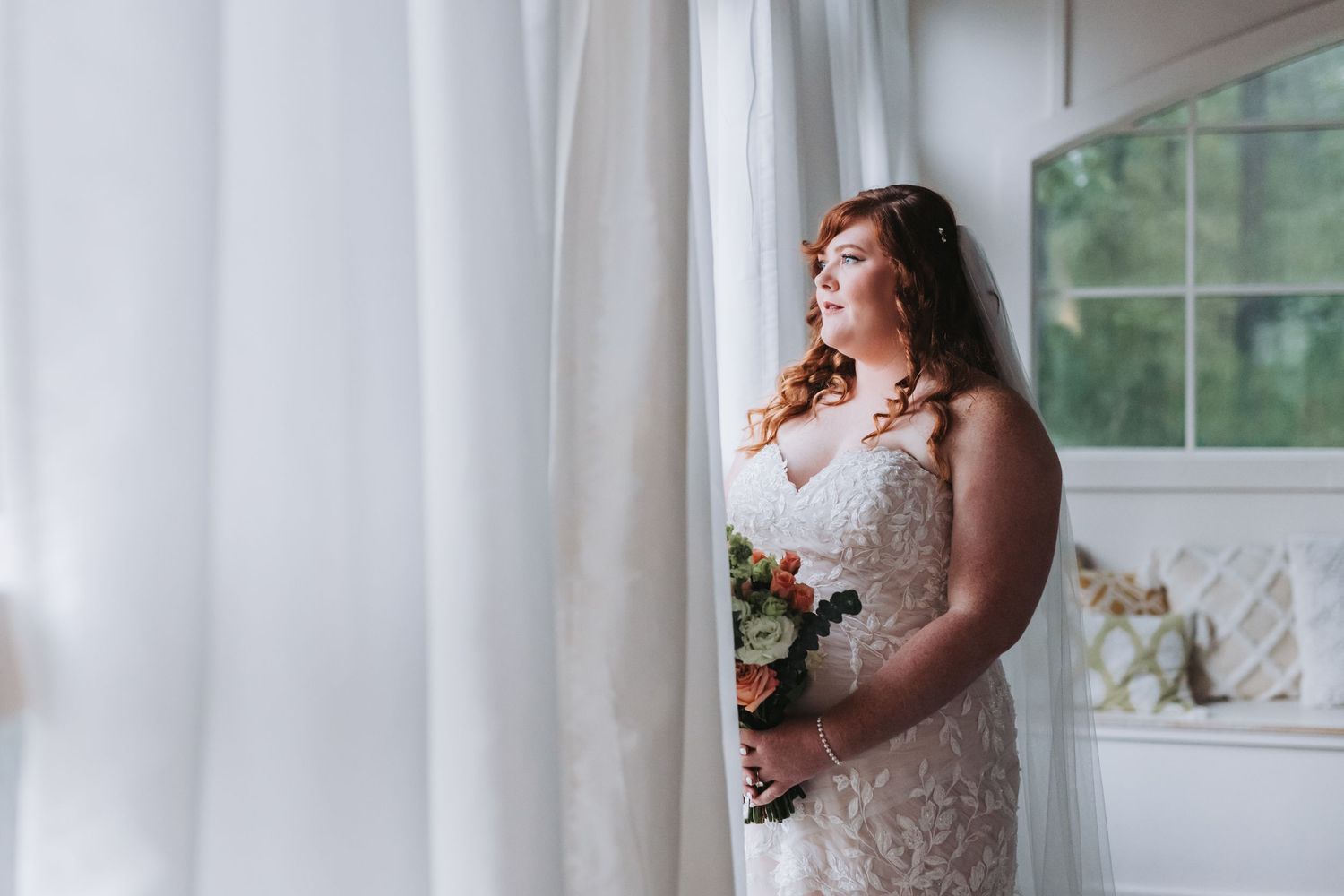 Newlyweds share a romantic moment outdoors under white pillars with string lights at dusk during their wedding celebration.