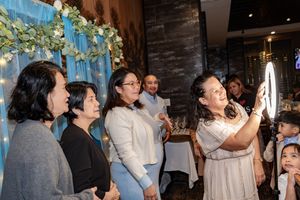 People celebrate and dance together at a lively indoor party with stone walls and blue lighting.
