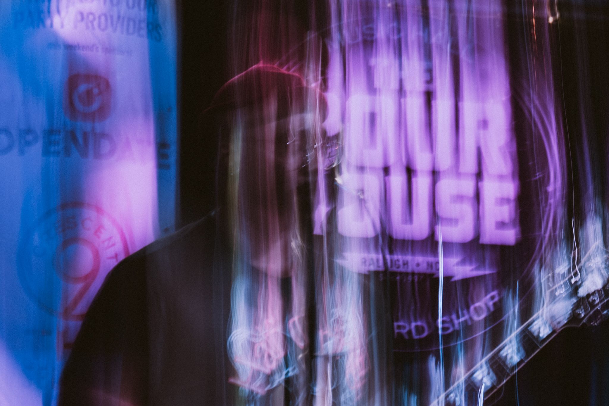 Abstract purple and blue stage lighting creating vertical motion blur effects.