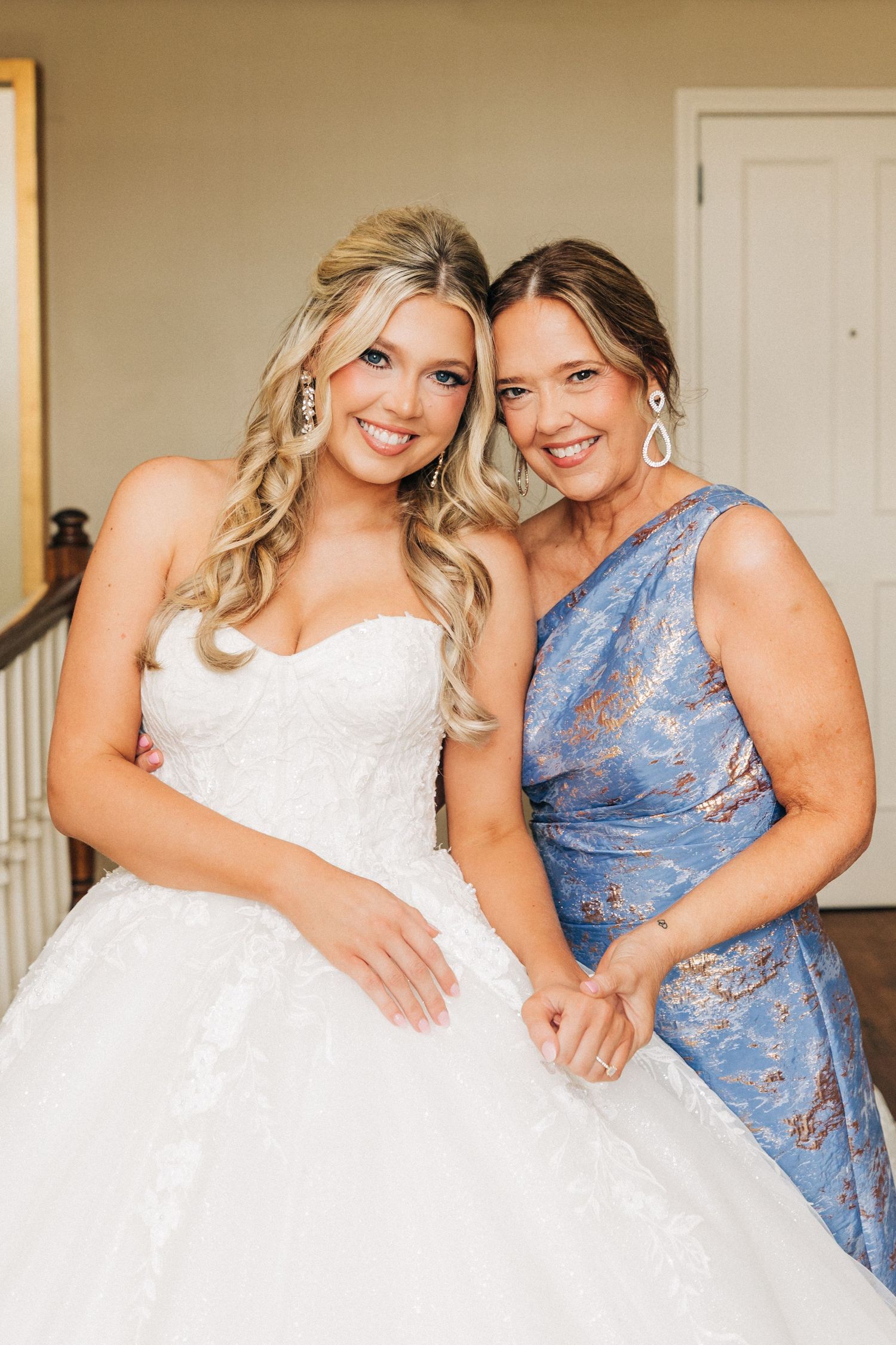 Two wedding guests in white and blue floral dresses pose together in a sweet progression of candid photos.