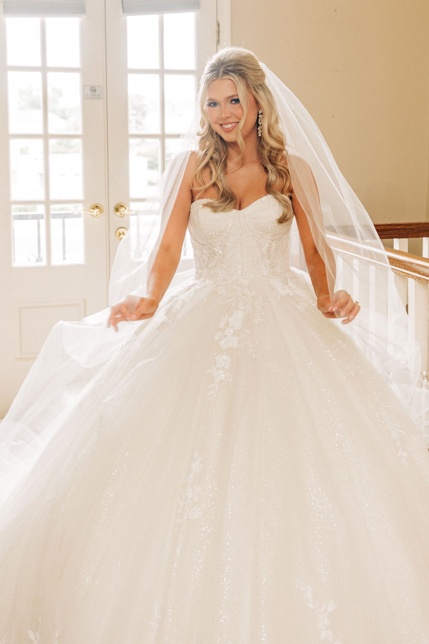 A gorgeous white ball gown wedding dress with delicate lace details, sweetheart neckline and flowing tulle veil.