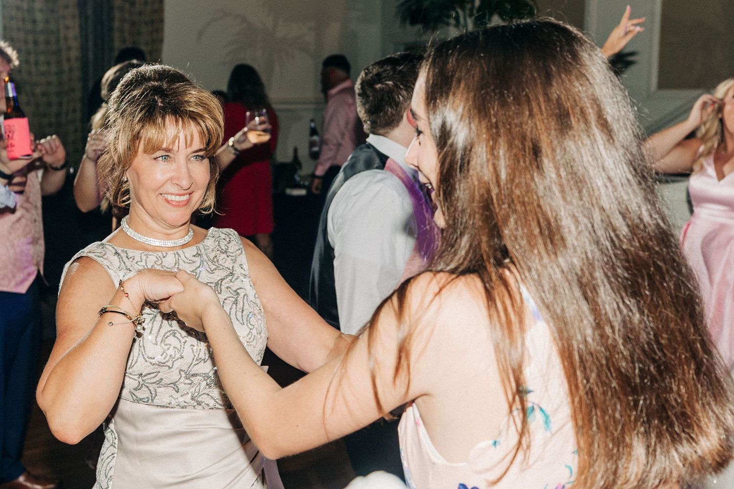 A lively dance party scene with people moving and mingling in a dimly lit venue.