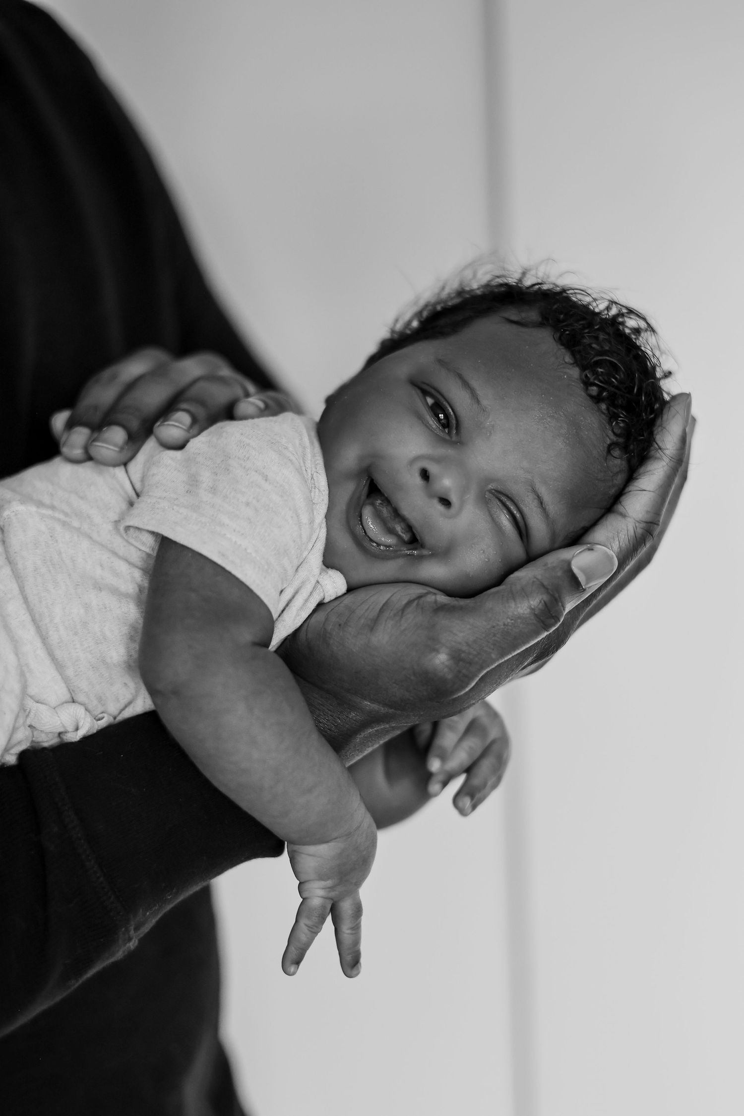 A black and white photo sequence showing a baby's emotional expressions and facial movements from different angles.