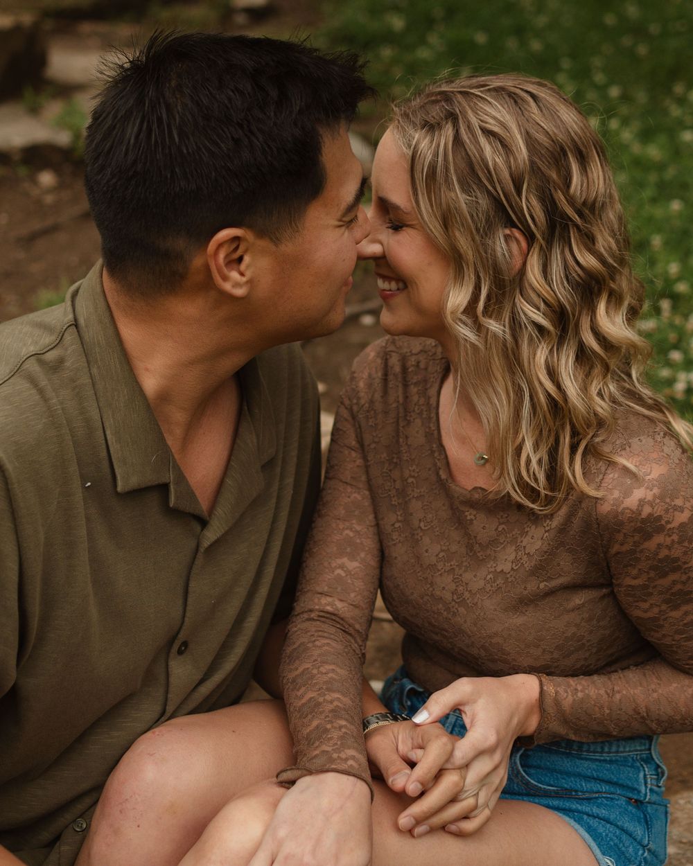 Series of romantic engagement photos captured in warm sunlight with couple embracing on a grassy hillside.