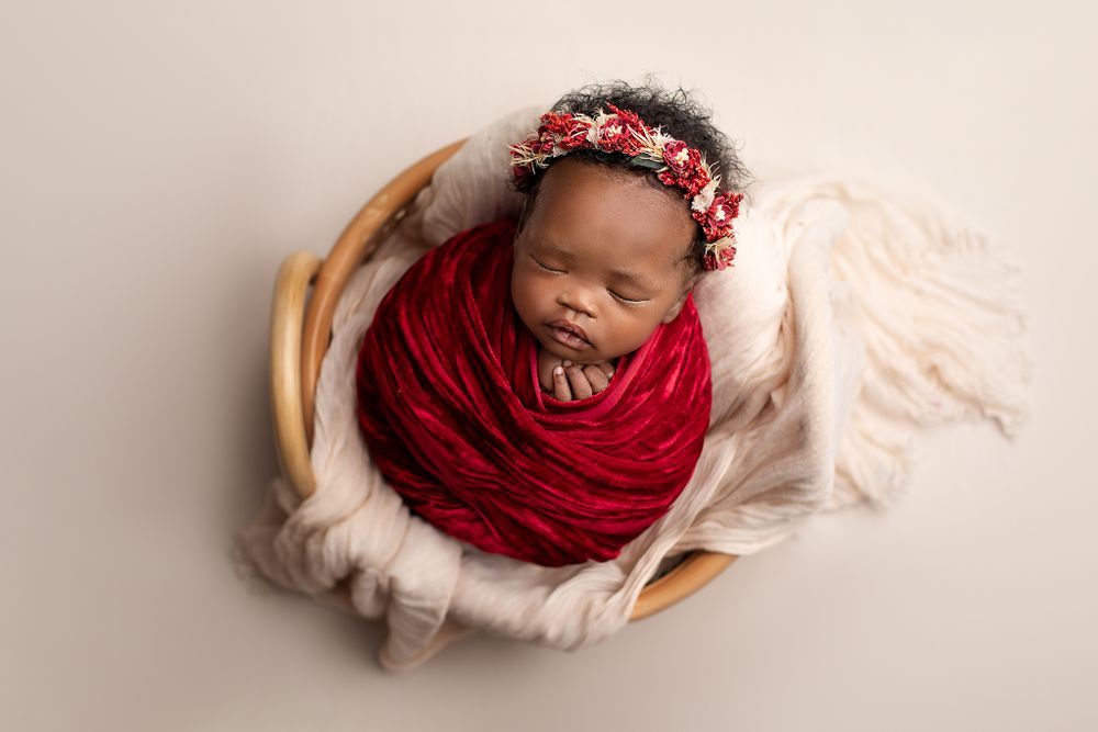 Affordable newborn photographer Ipswich Hospital – baby girl wrapped in red fabric with floral crown, professional studio portraits at Butto