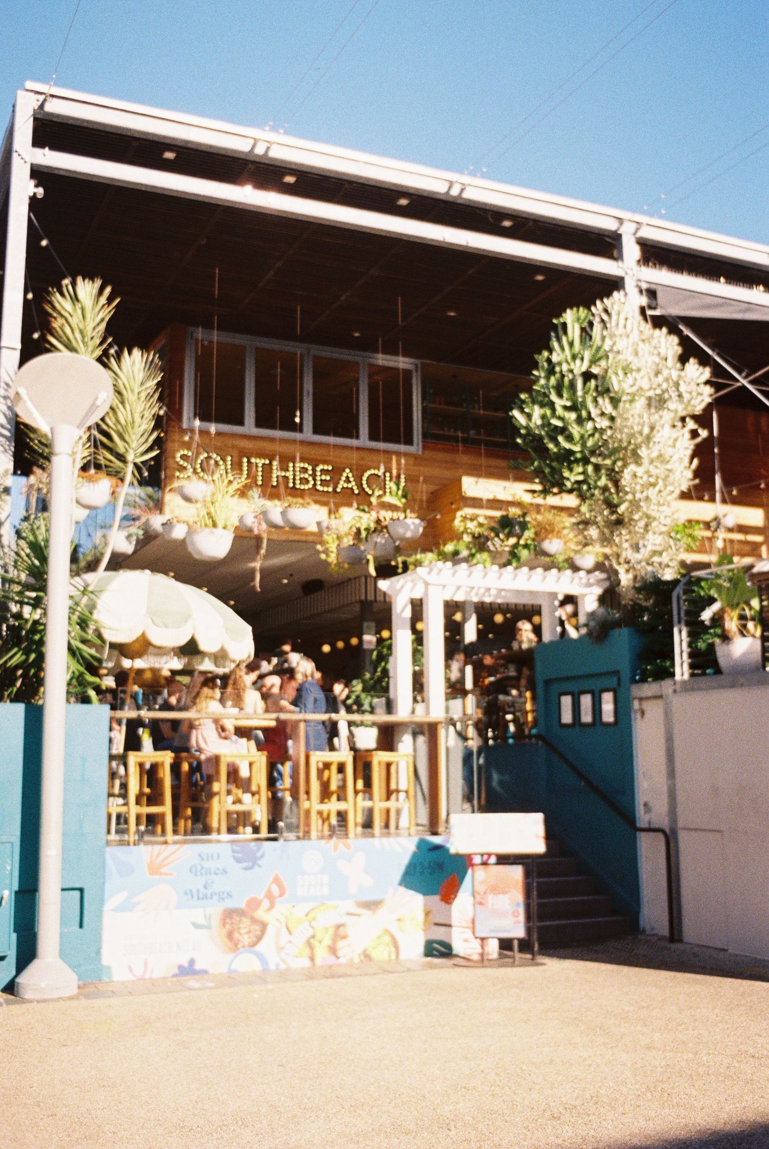 A beach-themed bar entrance with "SOUTH BEACH" signage and decorative pineapples on the exterior facade.