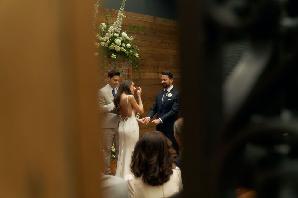 A couple in wedding attire stand close together in a garden during their wedding photo session at the Milling Room