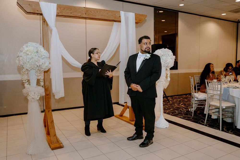A white and gold wedding chapel interior with a long mirror captures the formal ceremony setting and decor.