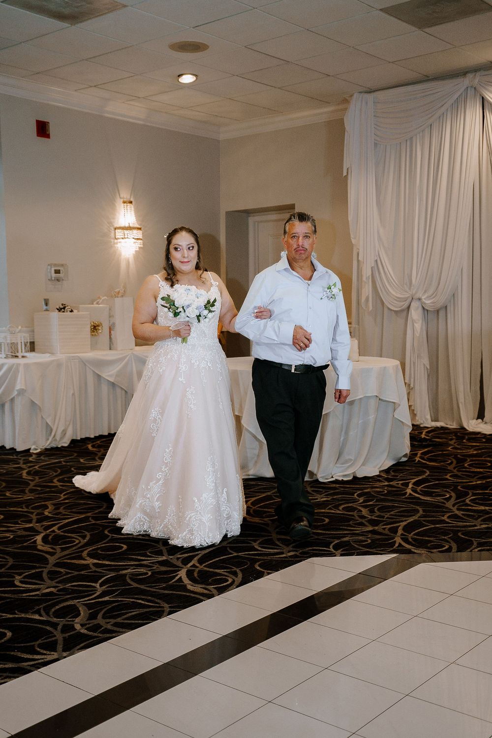Dance sequence at a wedding reception showing the bride in white dress and partner in formal attire on a black and white dance floor.