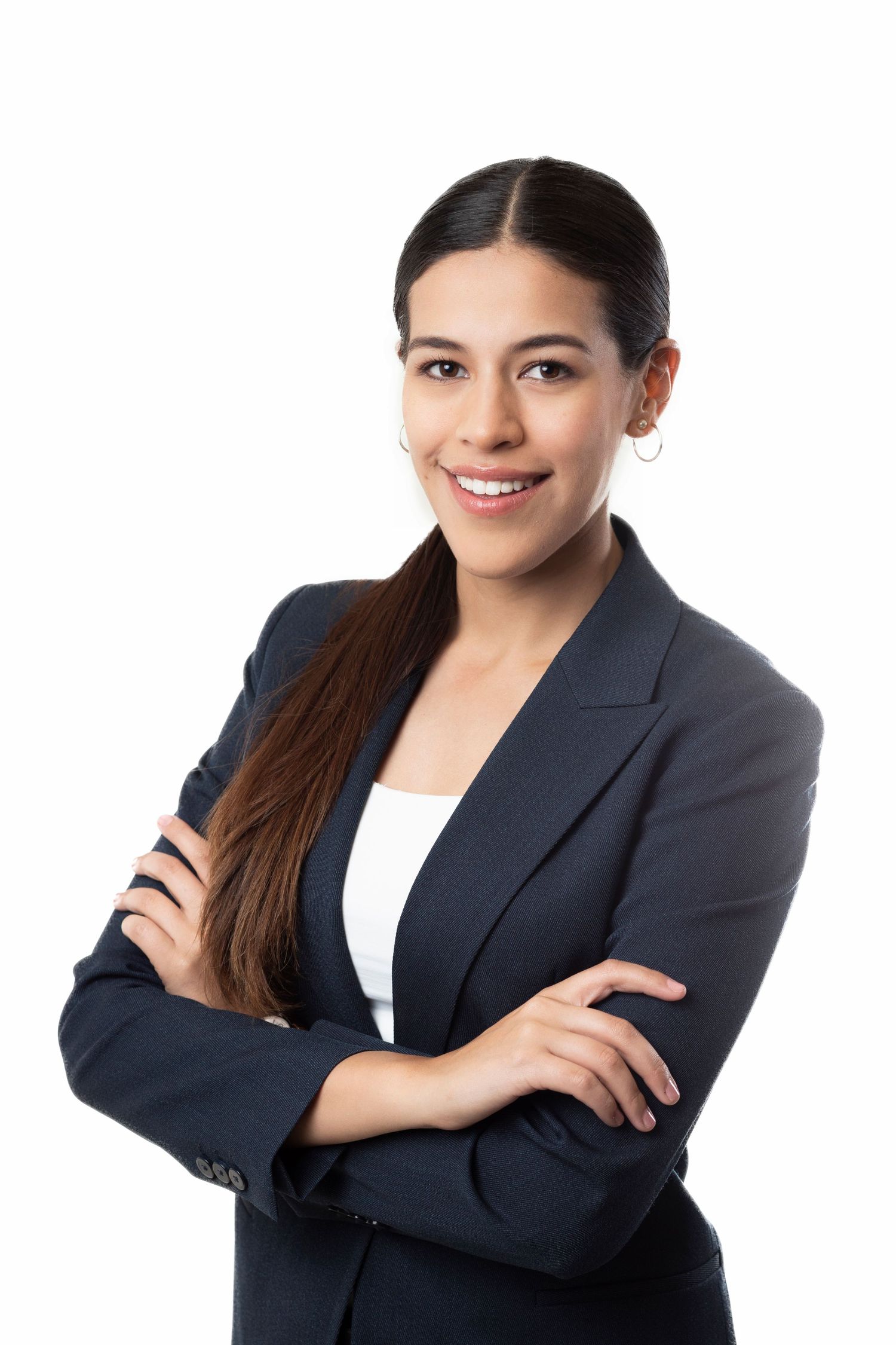 Professional headshot of person in navy blazer with long dark hair styled neatly against gray backdrop.