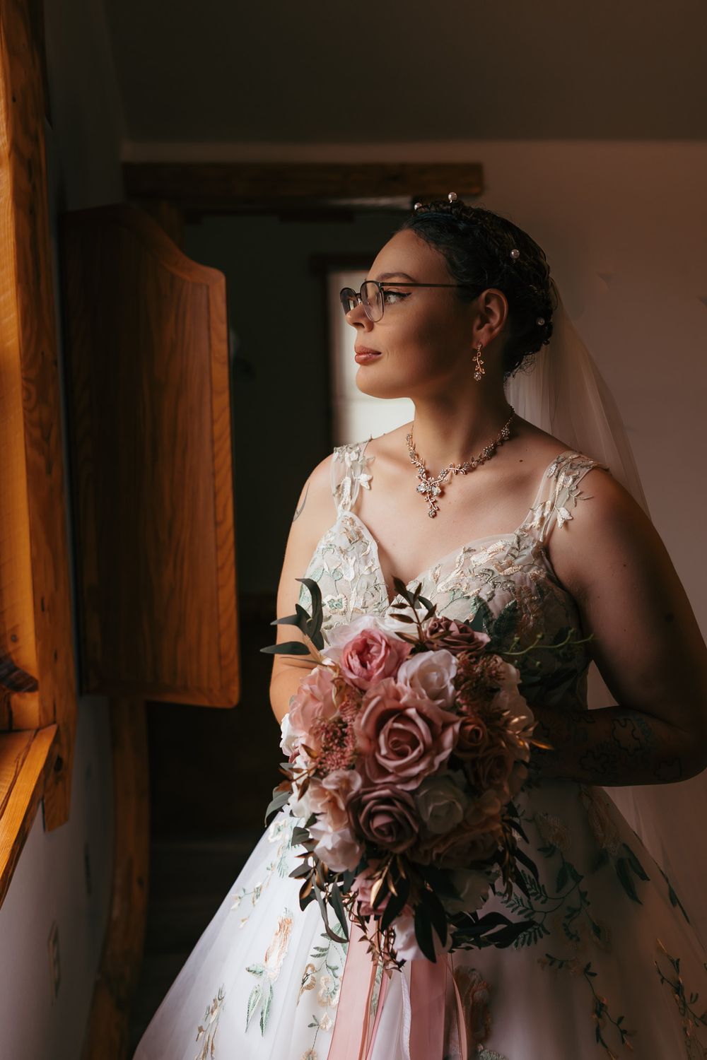 Bride looking out the window during her bridal portrait