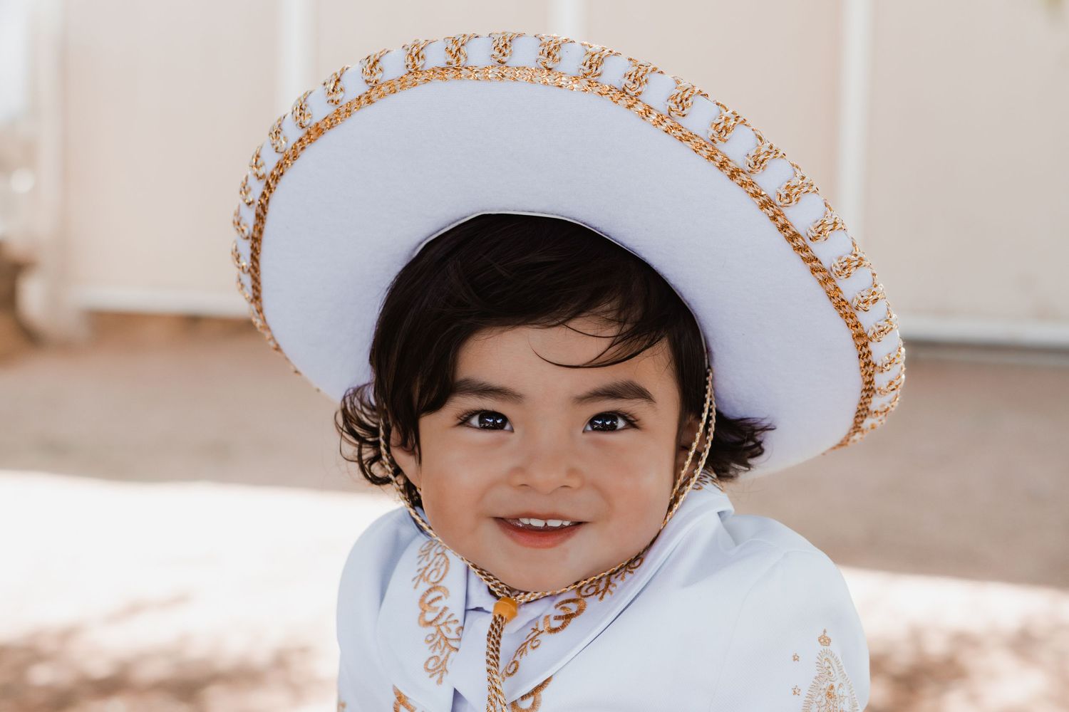 a toddler smiling at the camera in front of a barn.