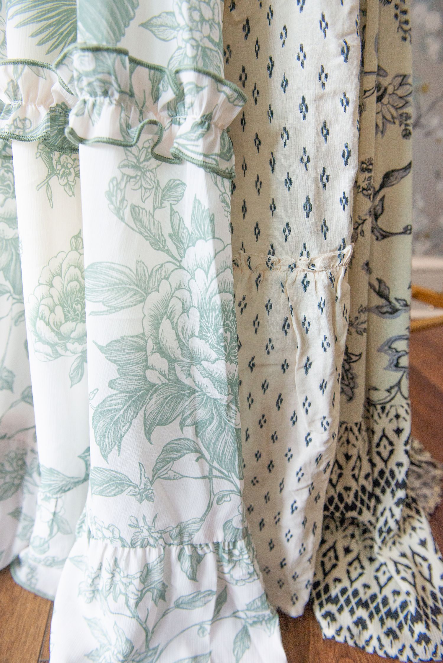 Close-up view of white curtains with mint green floral patterns and geometric trim details shown from multiple angles.