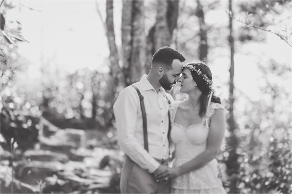 A romantic black and white moment captured in a wooded forest setting.
