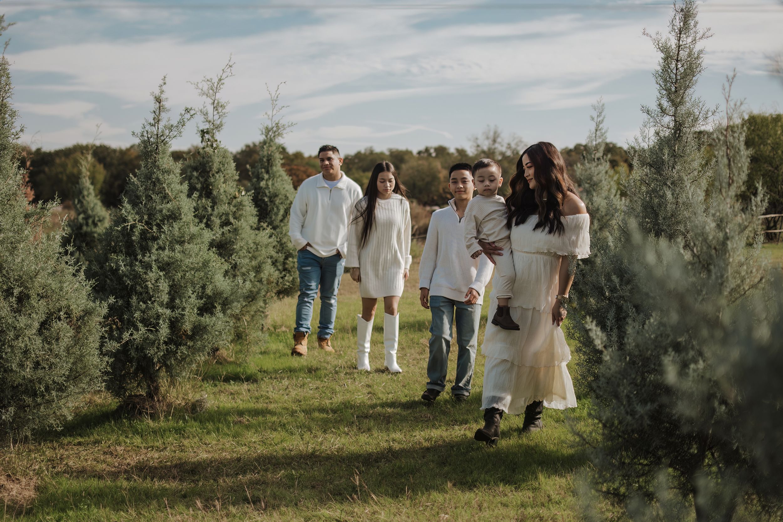 Dfw Tree Farm Wide landscape shots of a family photoshoot in a natural outdoor setting.
