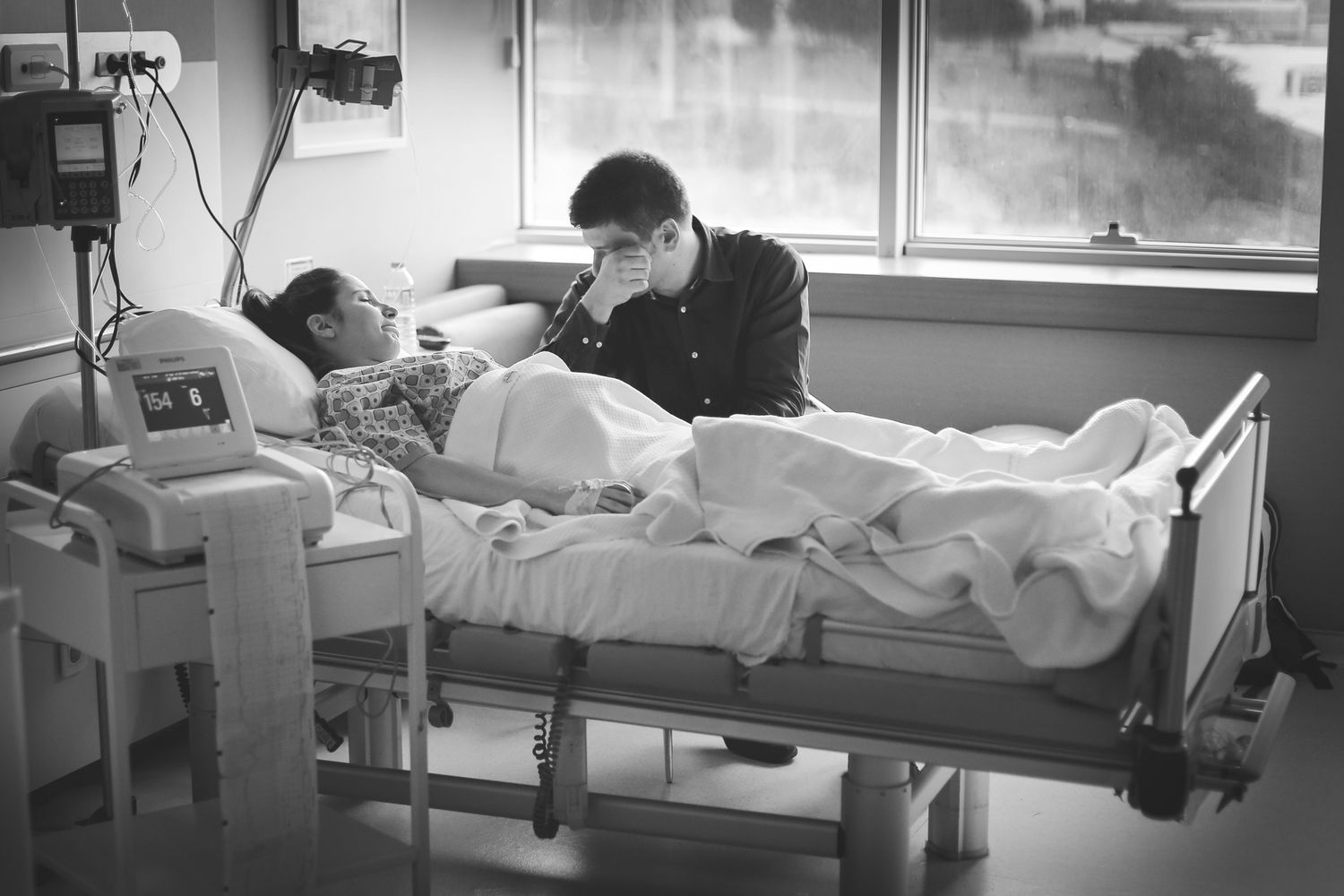 Medical staff attending to patients in hospital beds along a corridor during what appears to be an emergency situation.