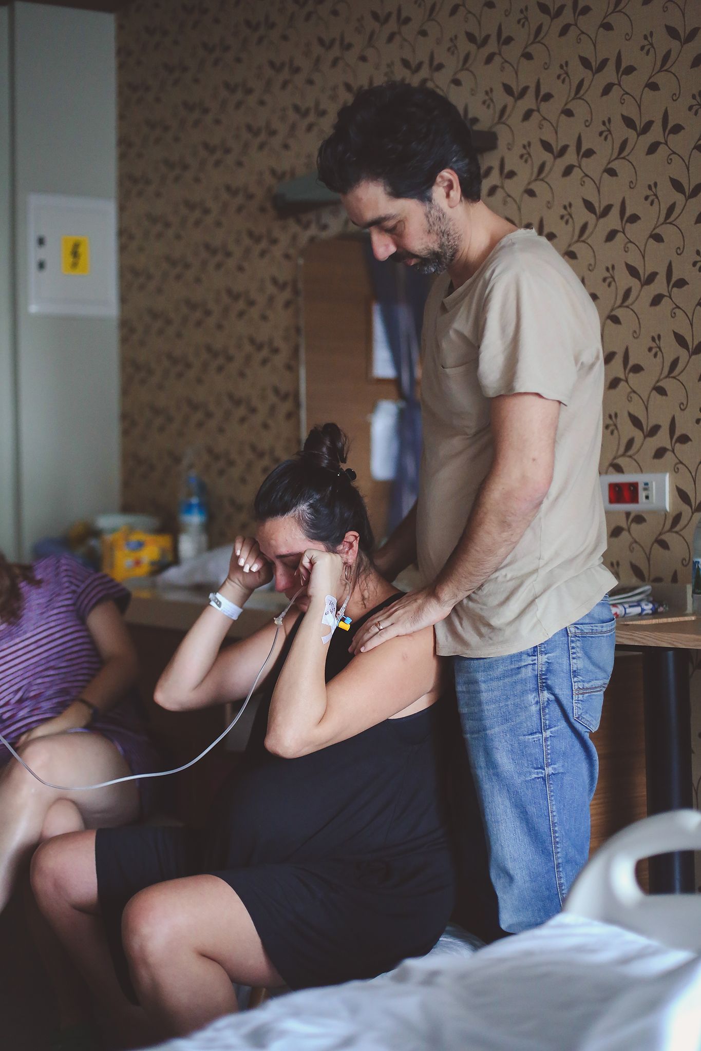 A couple shares a tender moment in a bedroom as they listen to music through earphones together.