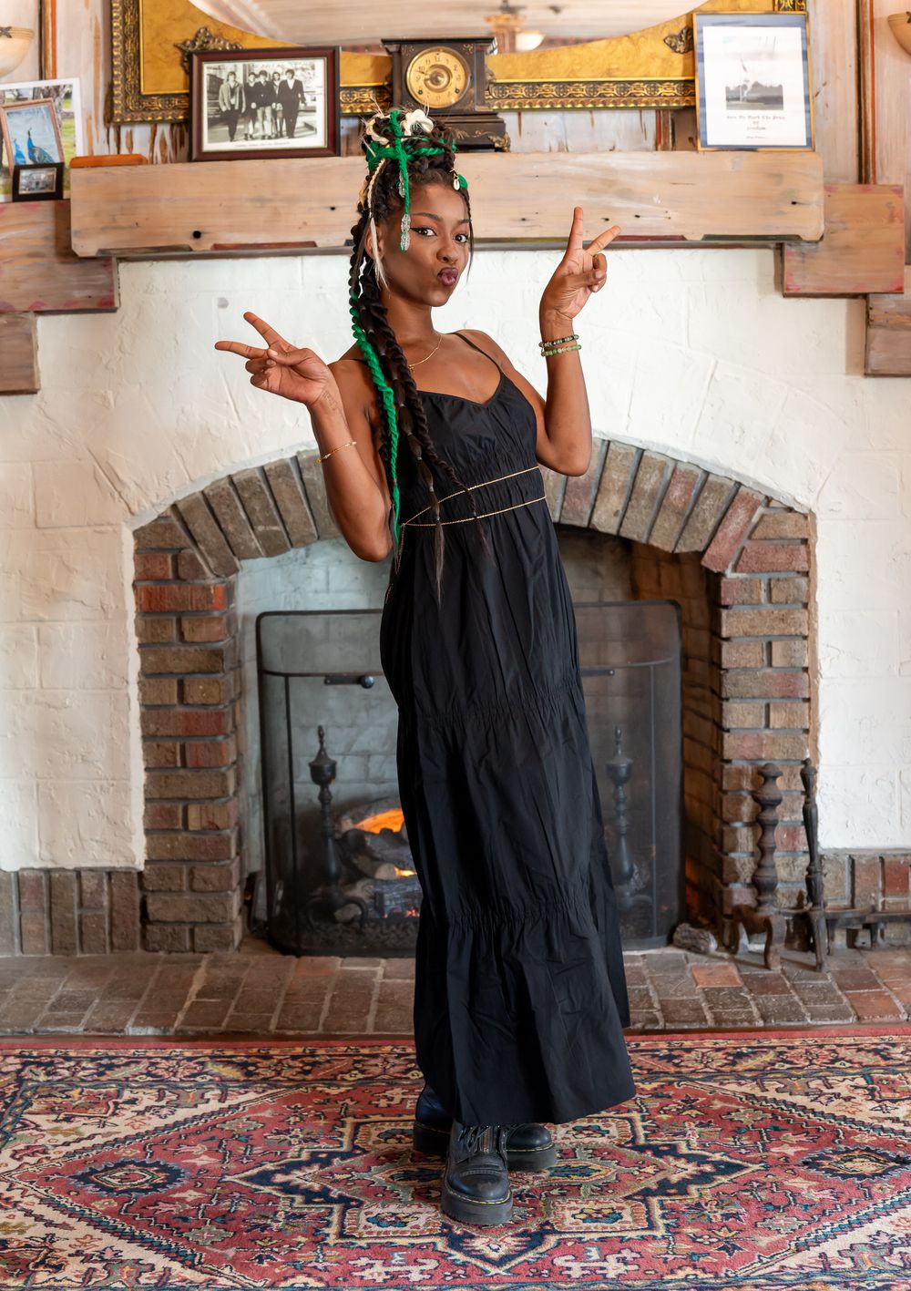 A person in a black dress performs a dance sequence across four connected images on a decorative rug.