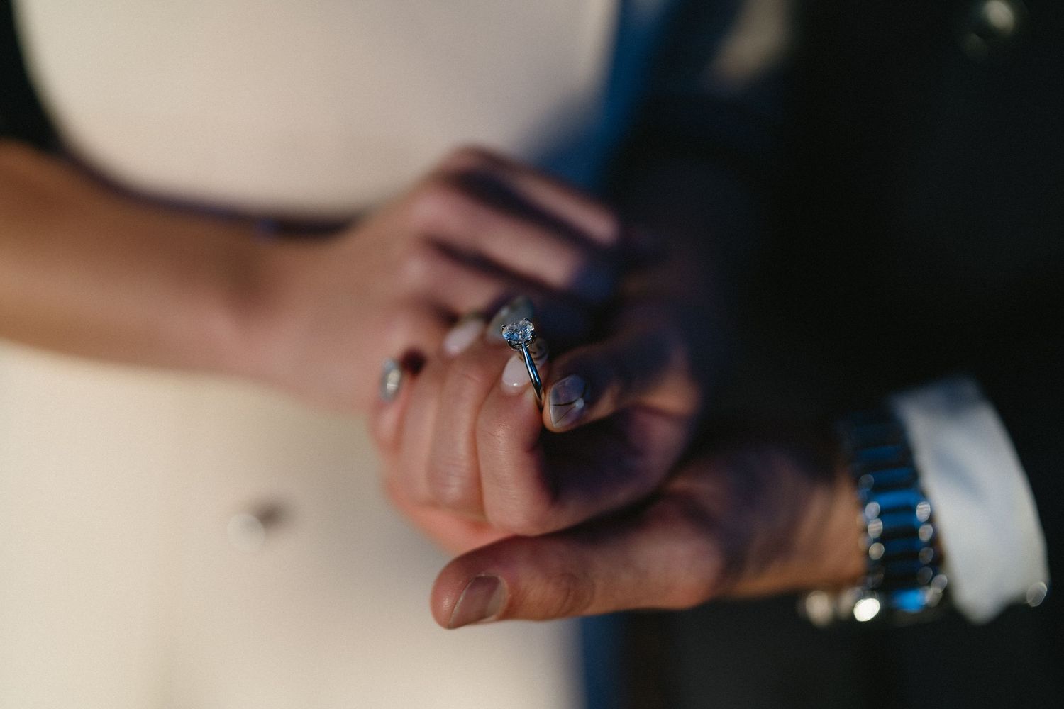 A person's hands pouring liquid into a glass during a wedding toast or celebration event.