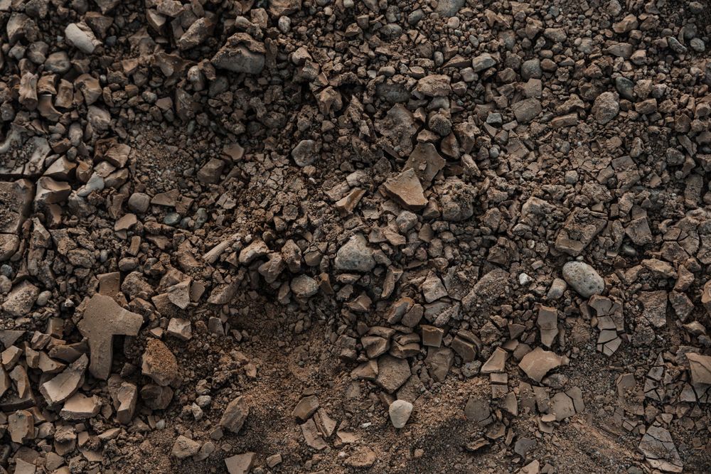 Detail shot of rough rocky terrain with scattered stones and gravel.