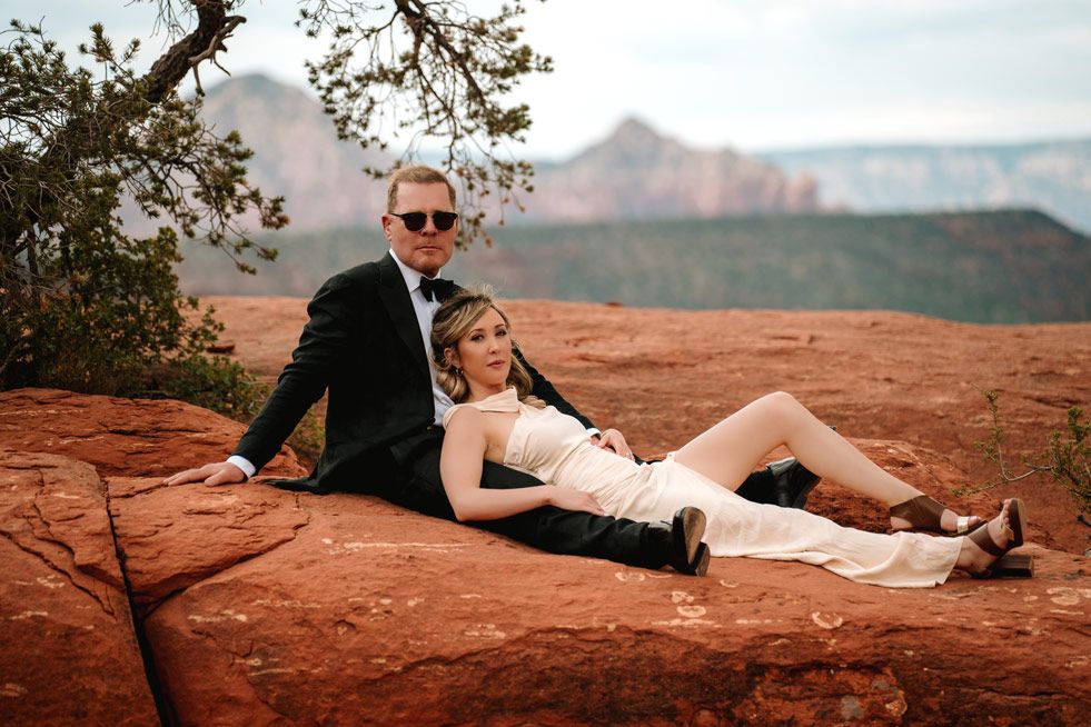 Casual moment on red rocks with Sedona mountain landscape in background.