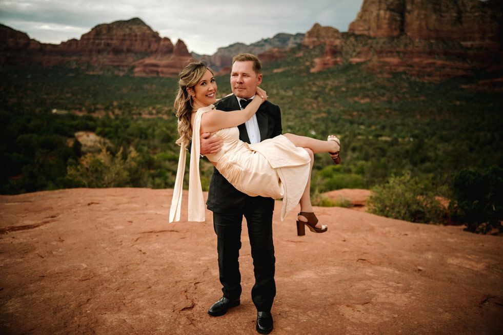 Romantic moment captured in front of majestic Sedona red rock formations.