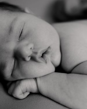 Close-up black and white portrait of sleeping newborn baby.