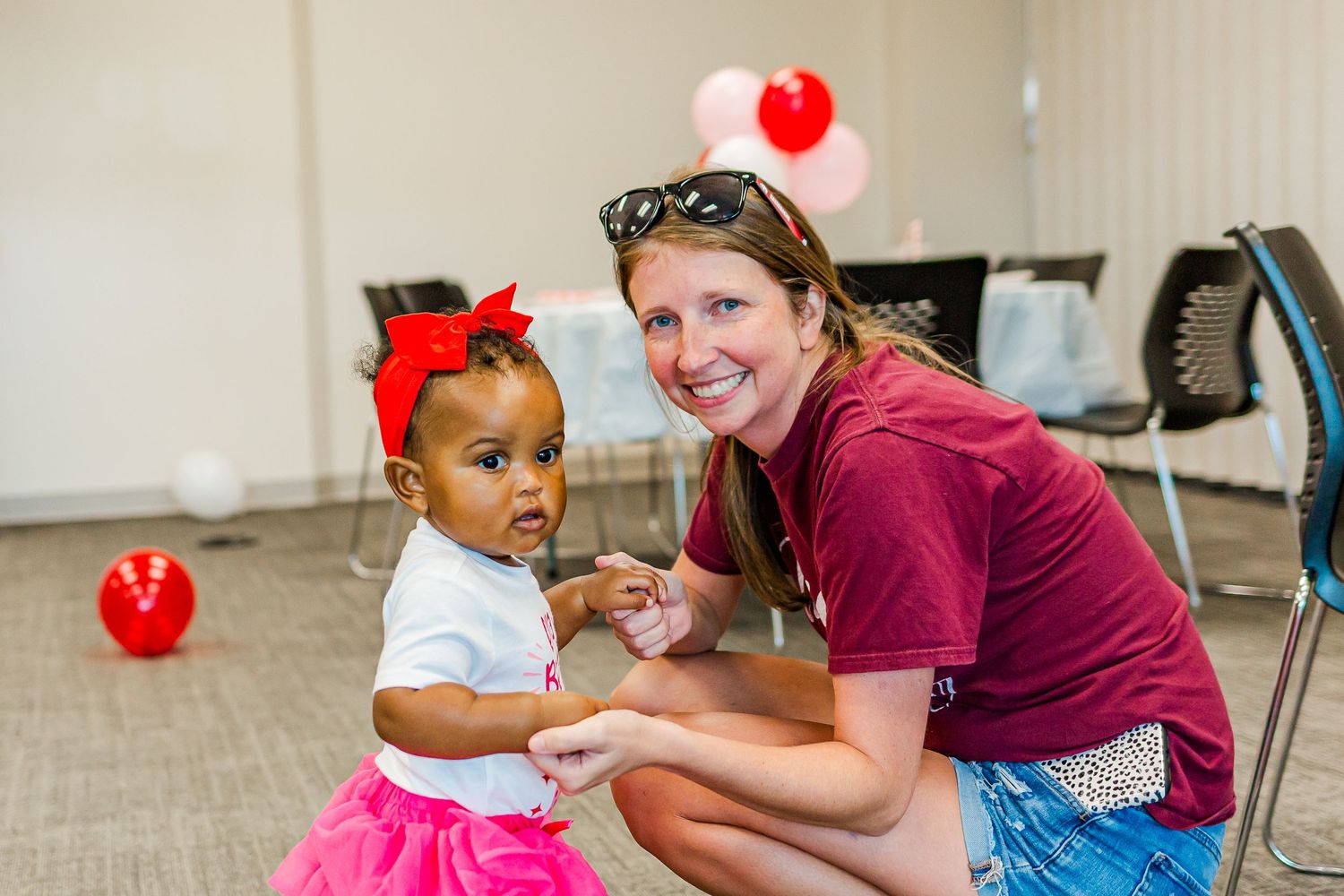 Strawberry-themed first birthday party celebration in a community room.
