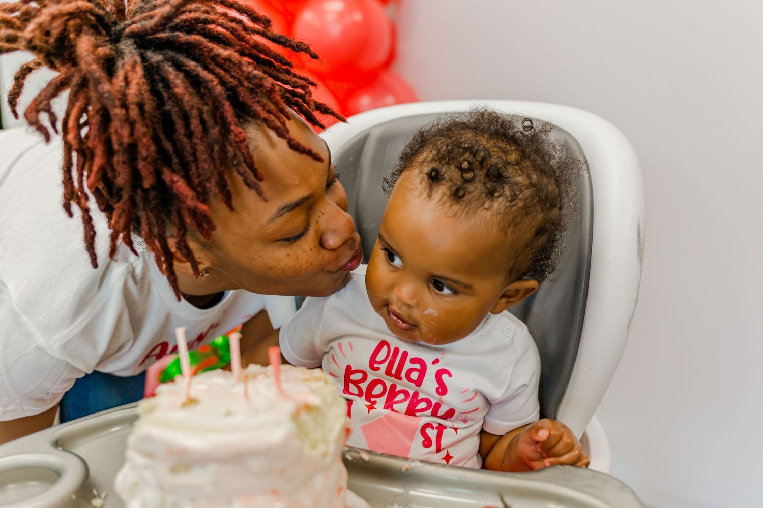 A birthday celebration with a lit cake showing a joyful tender moment between parent and child.