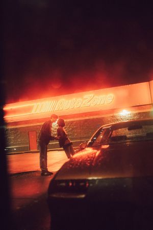 Red neon signage glows against a dark background creating a moody urban nighttime atmosphere.