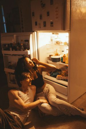 Three progressive images show a couple cuddling together indoors in soft, dim lighting.