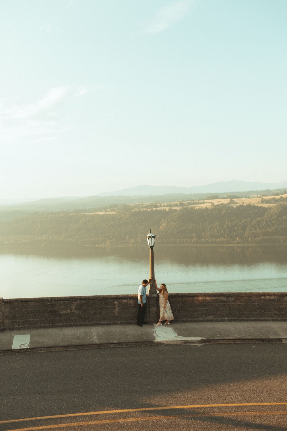 Panoramic sequence showing a person doing yoga poses on a stone wall overlooking a scenic lake at sunset.