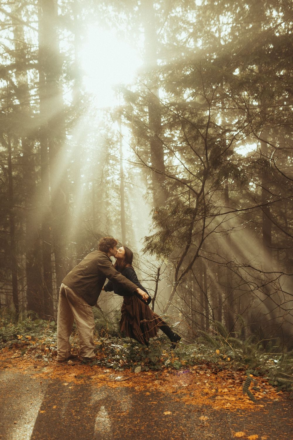 A figure in a dark coat dances gracefully through a misty autumn forest with sunbeams streaming through the trees.