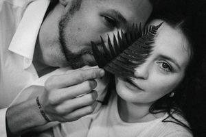 A black and white artistic portrait composition showing hands holding fern leaves against faces in multiple frames.