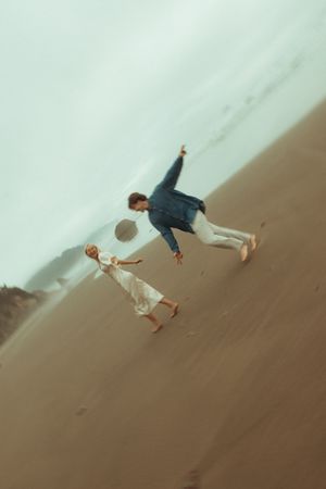 A person dune surfing down a steep sandy slope in the desert with the sky visible at the top.