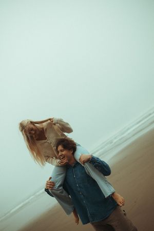 Two people dance and spin together on a foggy beach with ethereal lighting.