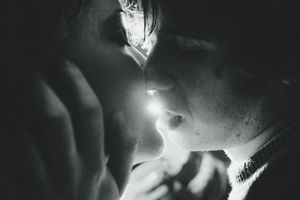 A dramatic black and white photo sequence showing a person blowing smoke rings in dark lighting conditions.