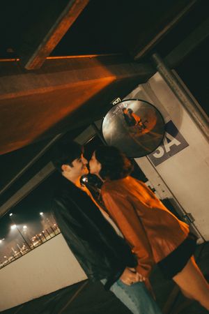 Low angle shot in dim lighting shows figures against an architectural backdrop with orange tints.