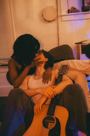 A series of warm-toned photos showing someone playing an acoustic guitar in intimate indoor lighting.